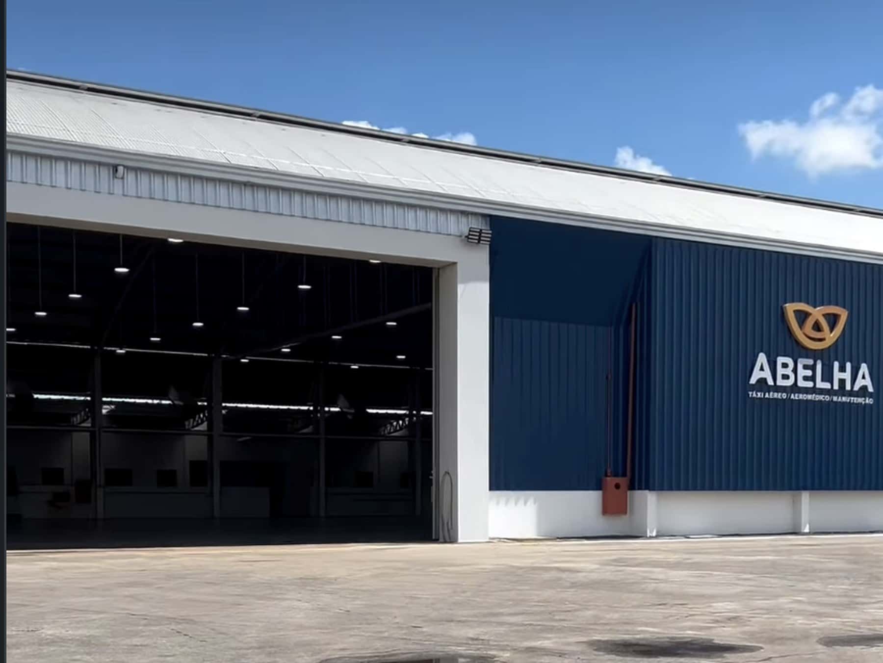 Hangar da Abelha com o portão aberto e o pátio de aeronaves em primeiro plano